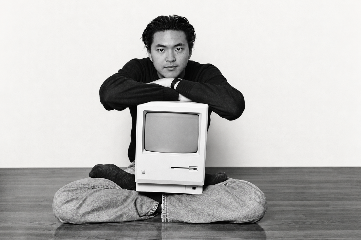 Creative black-and-white portrait of Jimmy seated behind a vintage Macintosh